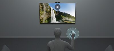 Grafic care arată o persoană care controlează televizorul prin gesturi