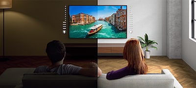 Imagine cu un cuplu stând pe canapea și uitându-se la televizor, cu o captură de ecran cu o barcă pe un râu, demonstrând avantajele oferite de senzorul de lumină