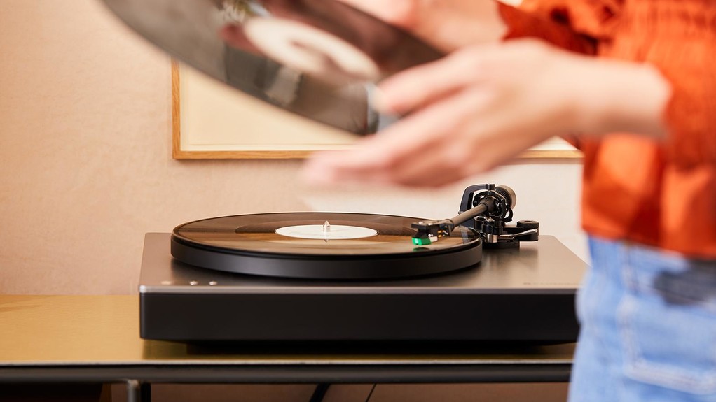 Person holding a record with the alva st turntable in the background