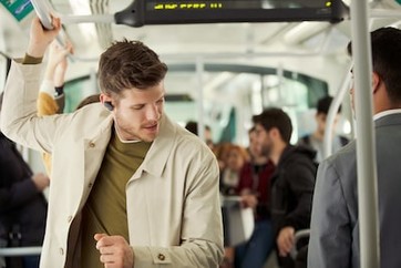 Imagine de stil de viaÅ£Ä cu un bÄrbat bucurându-se de cÄÅtile WF-1000XM3 într-un mijloc de transport în comun.