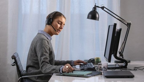 adapt-200---womand-at-desk-working-with-headphones-on