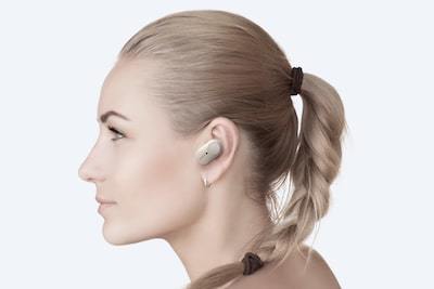 Fotografie de studio cu o femeie purtând cÄÅtile WF-1000XM3 cu comenzi tactile personalizabile.