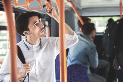 Person on a bus listening to an announcement using Ambient Sound mode