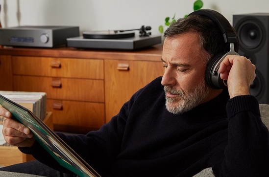 Man in dark sweater, wearing headphones and listening to music